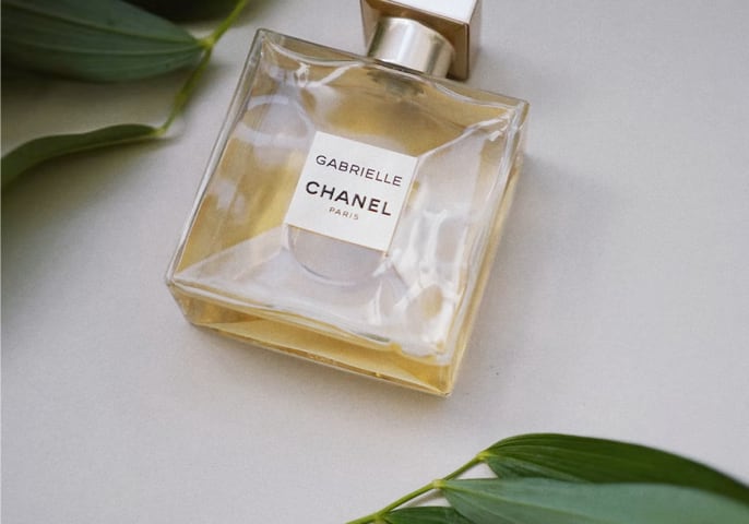 Product image (a perfume bottle accompanied with some leaves).